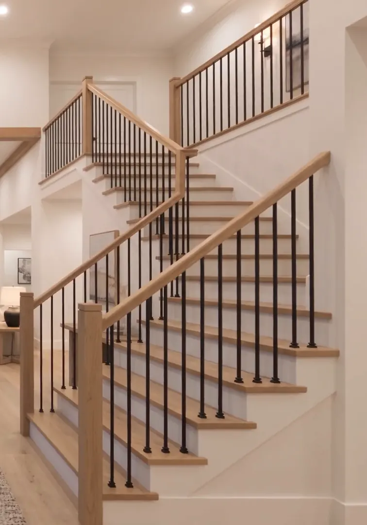 The oak and iron stair rising from the foyer
